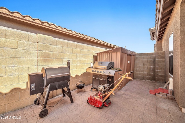 view of patio with grilling area and a storage unit