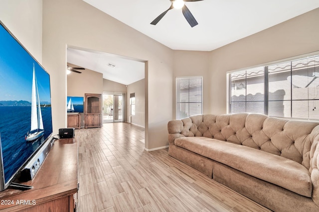 living room featuring ceiling fan, light hardwood / wood-style flooring, and lofted ceiling