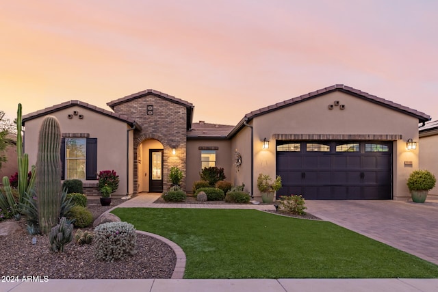 mediterranean / spanish house featuring a garage and a lawn