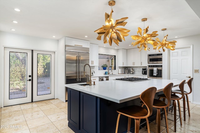 kitchen with white cabinetry, a center island, stainless steel appliances, pendant lighting, and decorative backsplash