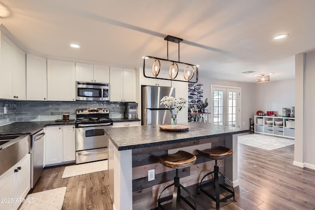 1718 W Voltaire Ave, Phoenix, AZ 85029 - kitchen featuring appliances with stainless steel finishes, dark countertops, dark wood-style floors, decorative backsplash, and recessed lighting