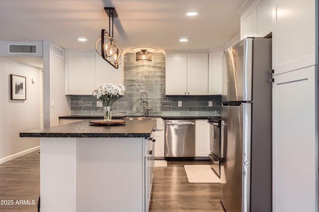 1718 W Voltaire Ave, Phoenix, AZ 85029 - kitchen featuring appliances with stainless steel finishes, dark countertops, a sink, white cabinetry, and dark wood finished floors