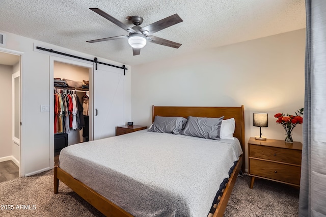 1718 W Voltaire Ave, Phoenix, AZ 85029 - bedroom featuring a barn door, carpet, a textured ceiling, a walk in closet, and ceiling fan
