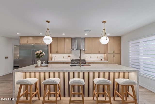 8119 E San Miguel Ave, Scottsdale, AZ 85250 - kitchen with stainless steel built in refrigerator, wall chimney range hood, backsplash, light brown cabinets, and a breakfast bar area