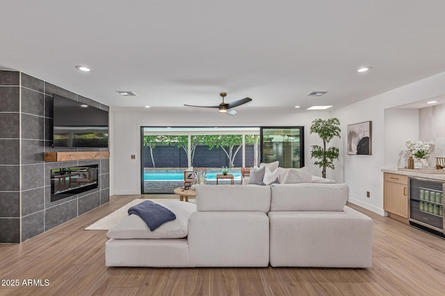 8119 E San Miguel Ave, Scottsdale, AZ 85250 - living room with wine cooler, light wood finished floors, recessed lighting, and a tile fireplace