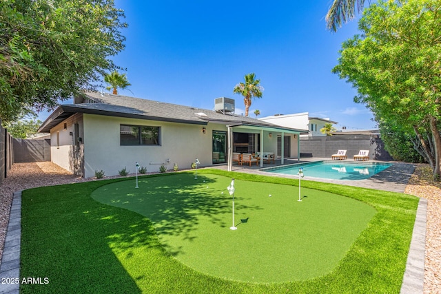8119 E San Miguel Ave, Scottsdale, AZ 85250 - rear view of property with a putting green, stucco siding, a patio, a fenced backyard, and roof with shingles