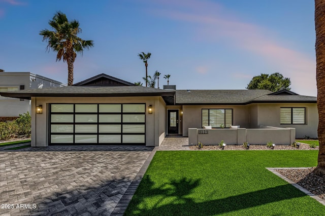 8119 E San Miguel Ave, Scottsdale, AZ 85250 - single story home featuring decorative driveway, an attached garage, a lawn, stucco siding, and roof with shingles