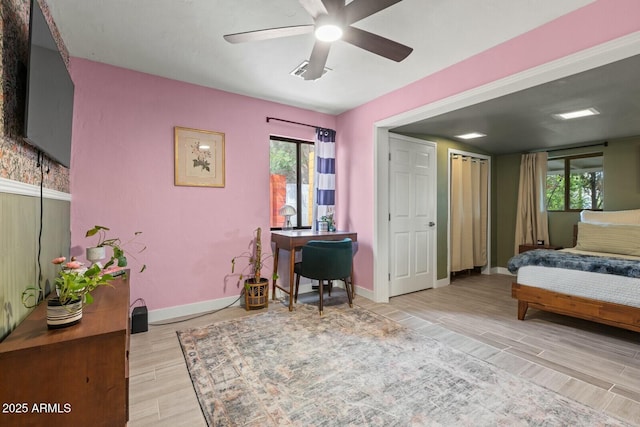 bedroom featuring a ceiling fan, baseboards, visible vents, and wood finish floors