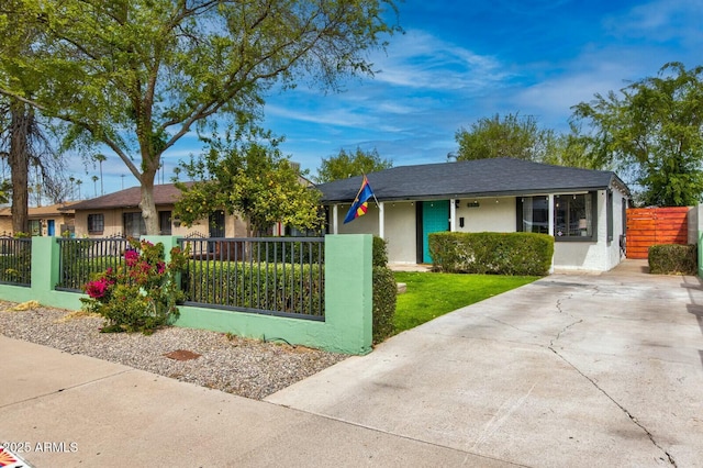ranch-style house featuring stucco siding, a fenced front yard, and driveway