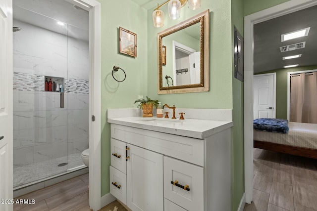 bathroom with vanity, toilet, visible vents, and a marble finish shower