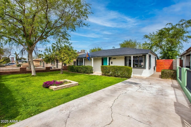 view of front facade with stucco siding, concrete driveway, a front lawn, and fence