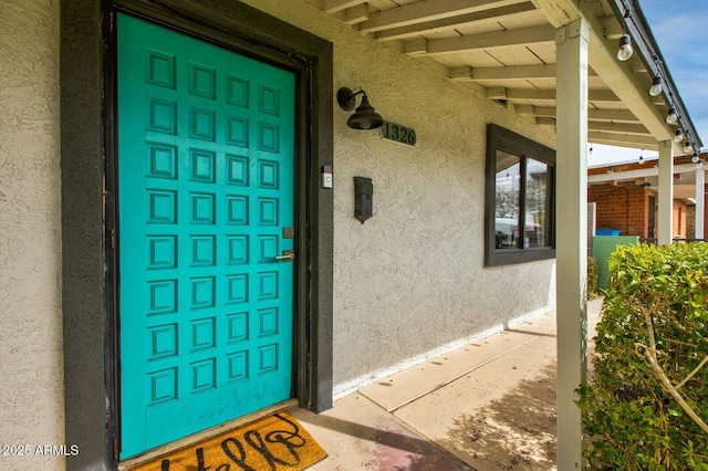 property entrance with stucco siding