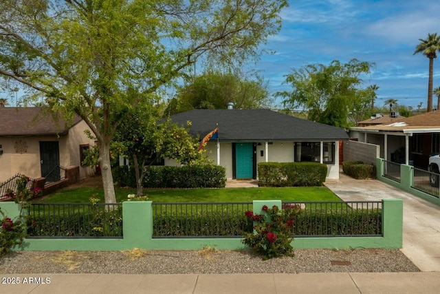 single story home with a fenced front yard, concrete driveway, a front yard, and stucco siding