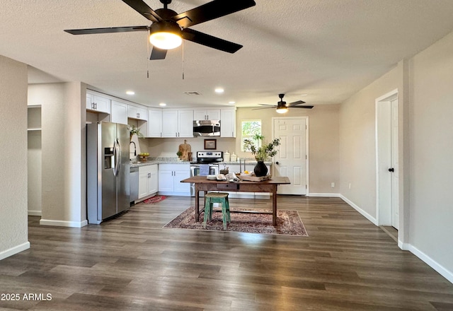 kitchen with dark hardwood / wood-style floors, white cabinetry, stainless steel appliances, and a textured ceiling