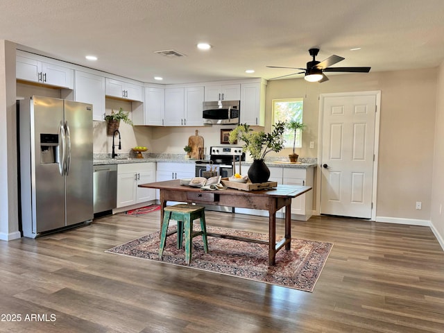 kitchen with white cabinetry, sink, ceiling fan, stainless steel appliances, and wood-type flooring