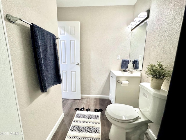 bathroom with vanity, wood-type flooring, and toilet