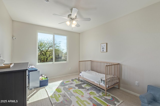 bedroom with baseboards, a ceiling fan, carpet flooring, and a nursery area