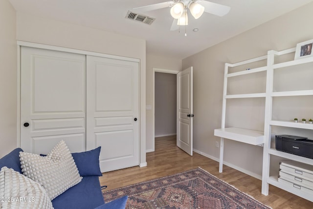 sitting room featuring wood finished floors, baseboards, ceiling fan, and visible vents