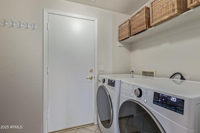 laundry area with separate washer and dryer, light tile patterned floors, and laundry area