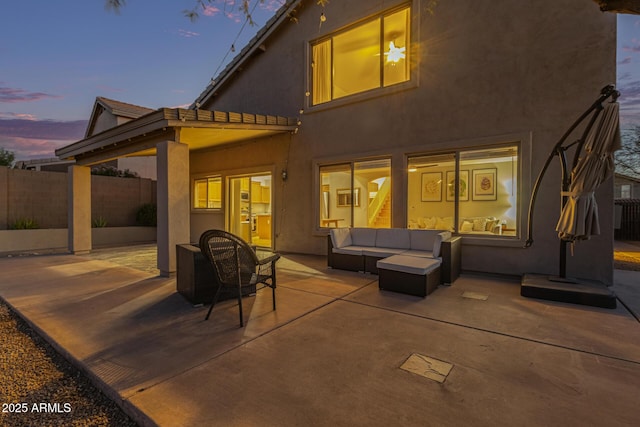 rear view of house featuring an outdoor hangout area, stucco siding, and a patio