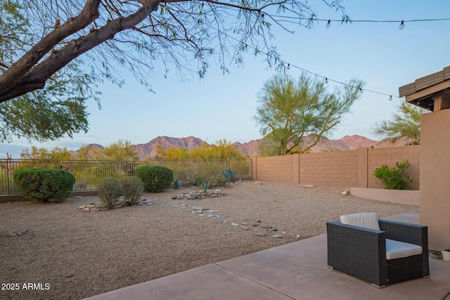 view of yard with a mountain view, a fenced backyard, and a patio area