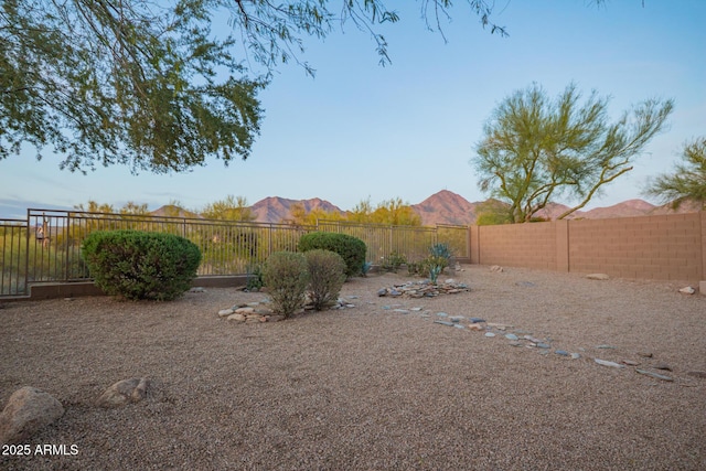 view of yard featuring a mountain view and a fenced backyard