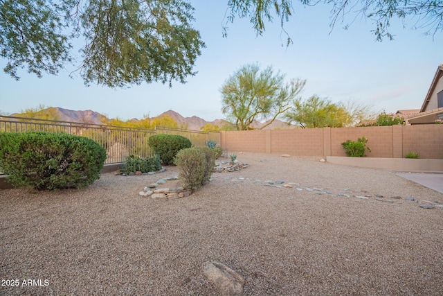 view of yard featuring a fenced backyard and a mountain view