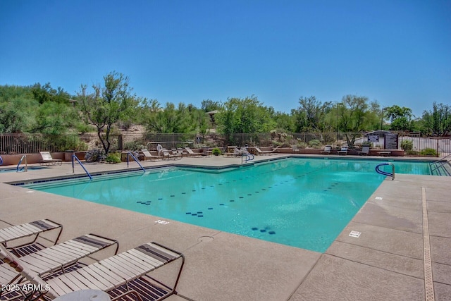 pool with a patio and fence