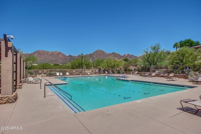 pool featuring a patio area, fence, and a mountain view
