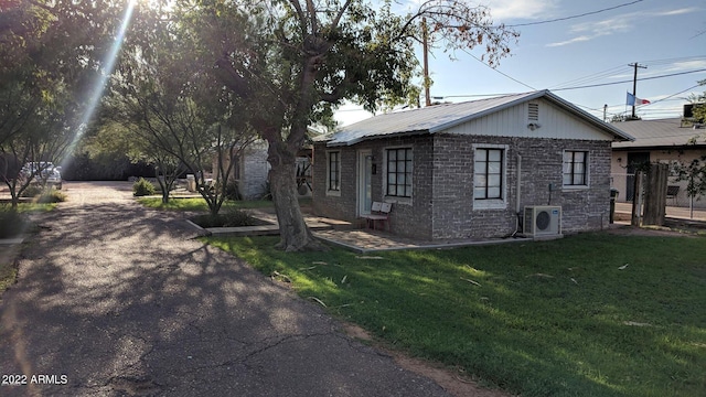 view of property exterior with ac unit and a lawn