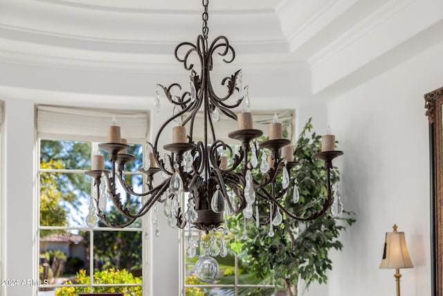 room details featuring ornamental molding and an inviting chandelier