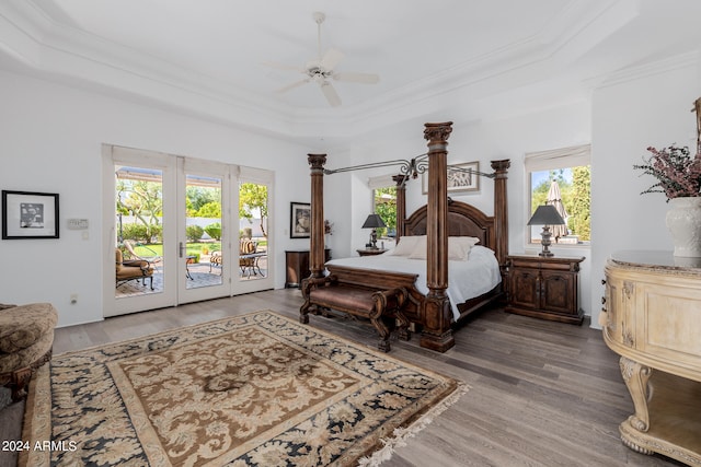 bedroom with ceiling fan, access to exterior, hardwood / wood-style floors, a raised ceiling, and ornamental molding