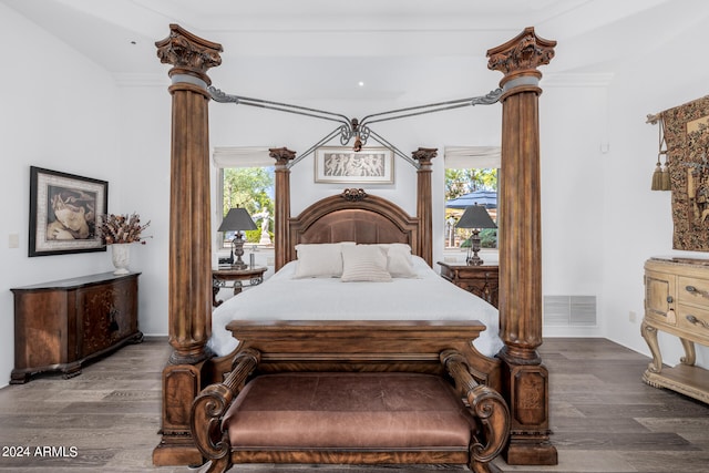 bedroom featuring ornamental molding, multiple windows, and hardwood / wood-style floors