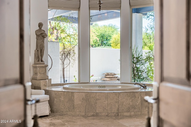 bathroom with tiled tub and plenty of natural light