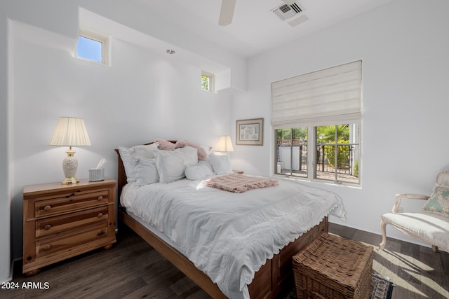 bedroom featuring dark hardwood / wood-style flooring, multiple windows, and ceiling fan