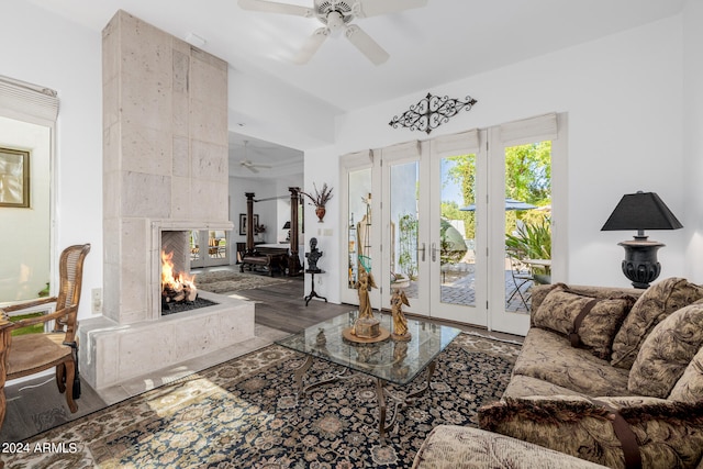 living room with ceiling fan, hardwood / wood-style floors, and a tiled fireplace