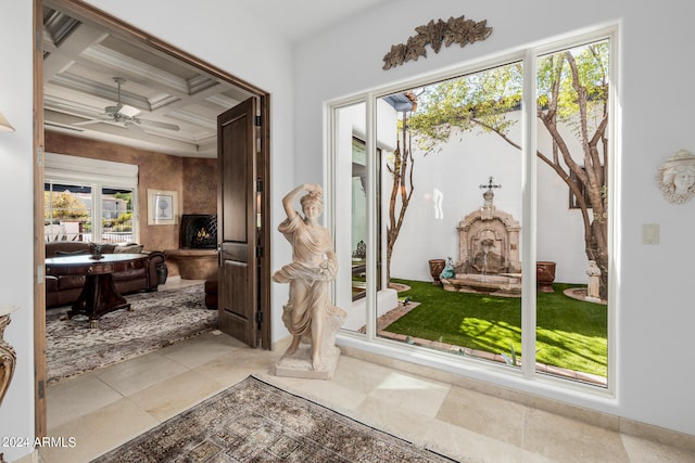 interior space with coffered ceiling, beamed ceiling, plenty of natural light, and ceiling fan