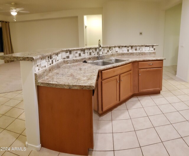 kitchen with ceiling fan, tasteful backsplash, light tile patterned flooring, and sink