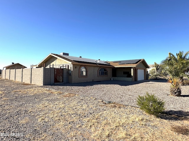 view of front of property with a garage and solar panels