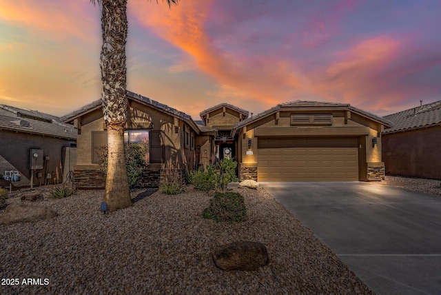 view of front of house featuring stone siding, an attached garage, driveway, and stucco siding