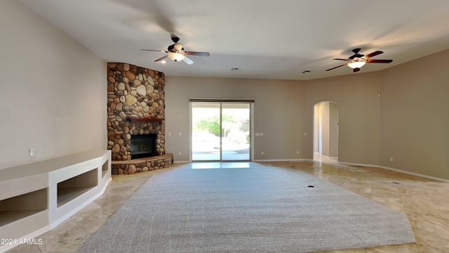 unfurnished living room featuring ceiling fan and a fireplace