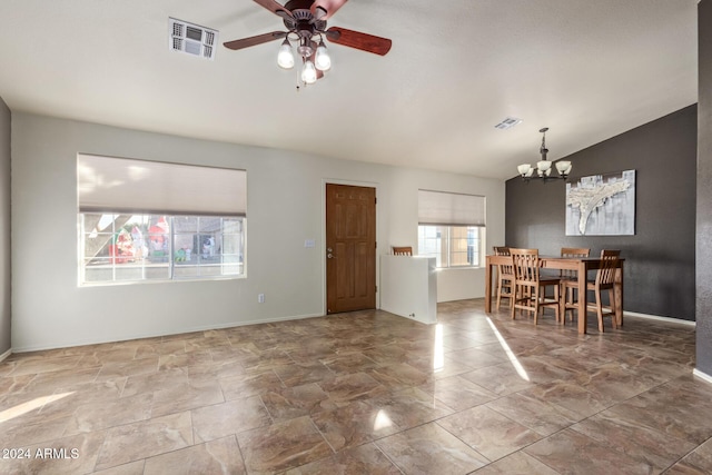 dining area with ceiling fan with notable chandelier and lofted ceiling