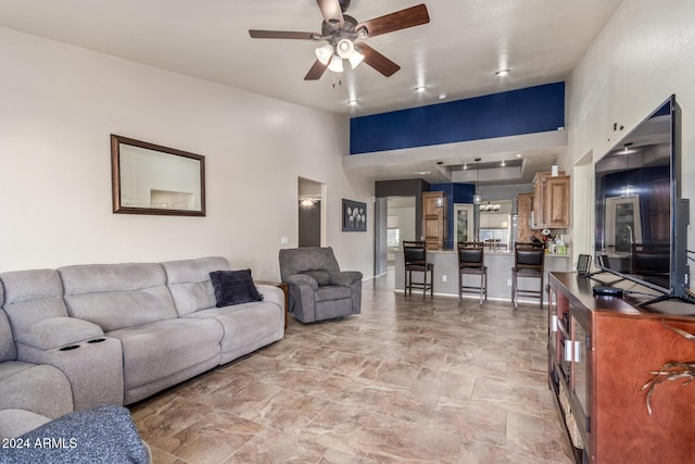 living room with ceiling fan and a high ceiling