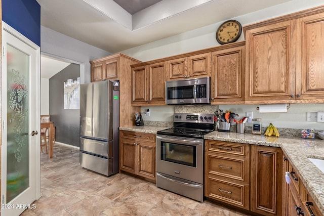 kitchen with light stone countertops and stainless steel appliances