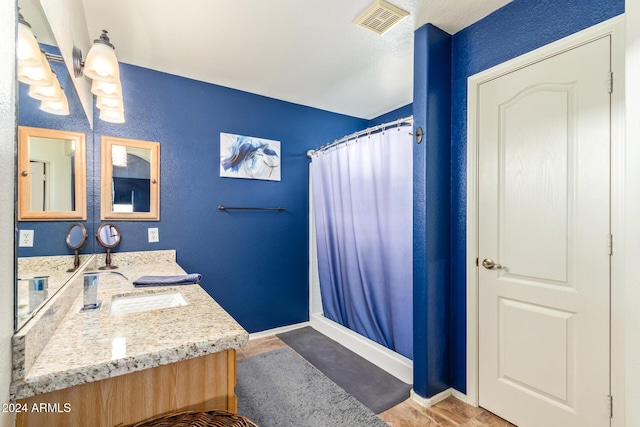 bathroom featuring hardwood / wood-style floors, vanity, and curtained shower