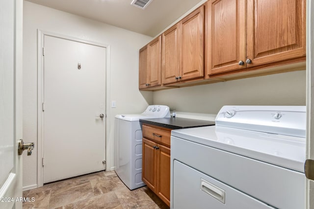 laundry room with cabinets and washing machine and clothes dryer