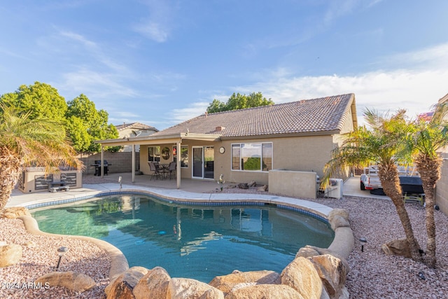 view of swimming pool featuring a patio and grilling area