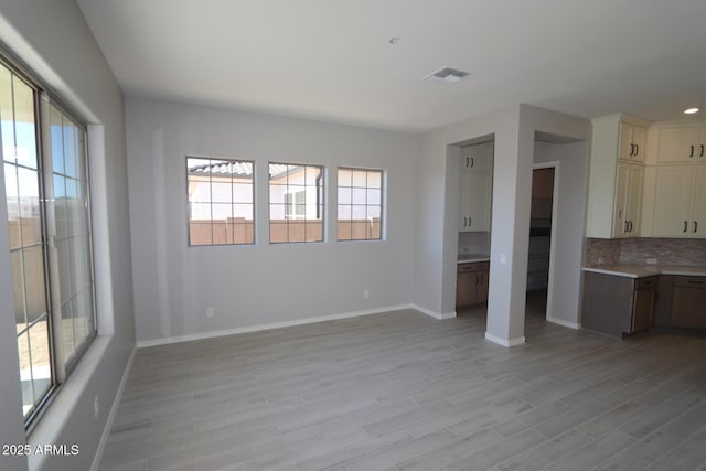 unfurnished living room with baseboards, visible vents, light wood-style flooring, and recessed lighting