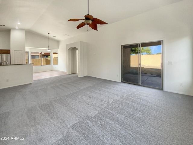 unfurnished living room featuring carpet, ceiling fan, and vaulted ceiling