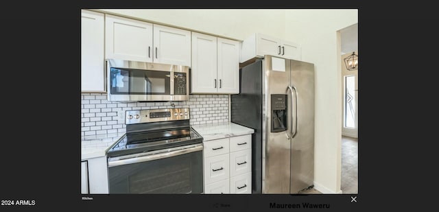 kitchen featuring decorative backsplash, light stone counters, white cabinetry, and stainless steel appliances